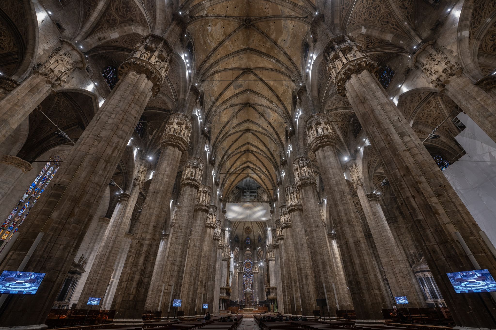 photo of Milan, Italy - Feb 5, 2020: People visit the Milan cathedral roof or duomo di Milano. It is a top tourist attraction of Milan. Panoramic view of beautiful gothic spires. Concept of travel in Italy.