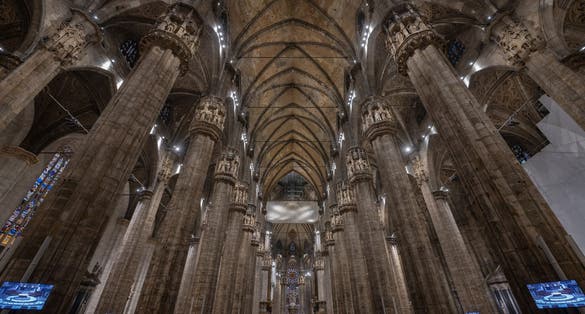 photo of Milan, Italy - Feb 5, 2020: People visit the Milan cathedral roof or duomo di Milano. It is a top tourist attraction of Milan. Panoramic view of beautiful gothic spires. Concept of travel in Italy.
