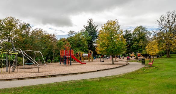 Photo of Large children playground area with slides, bars, swings and other equipment in Hazlehead park, Aberdeen, Scotland .