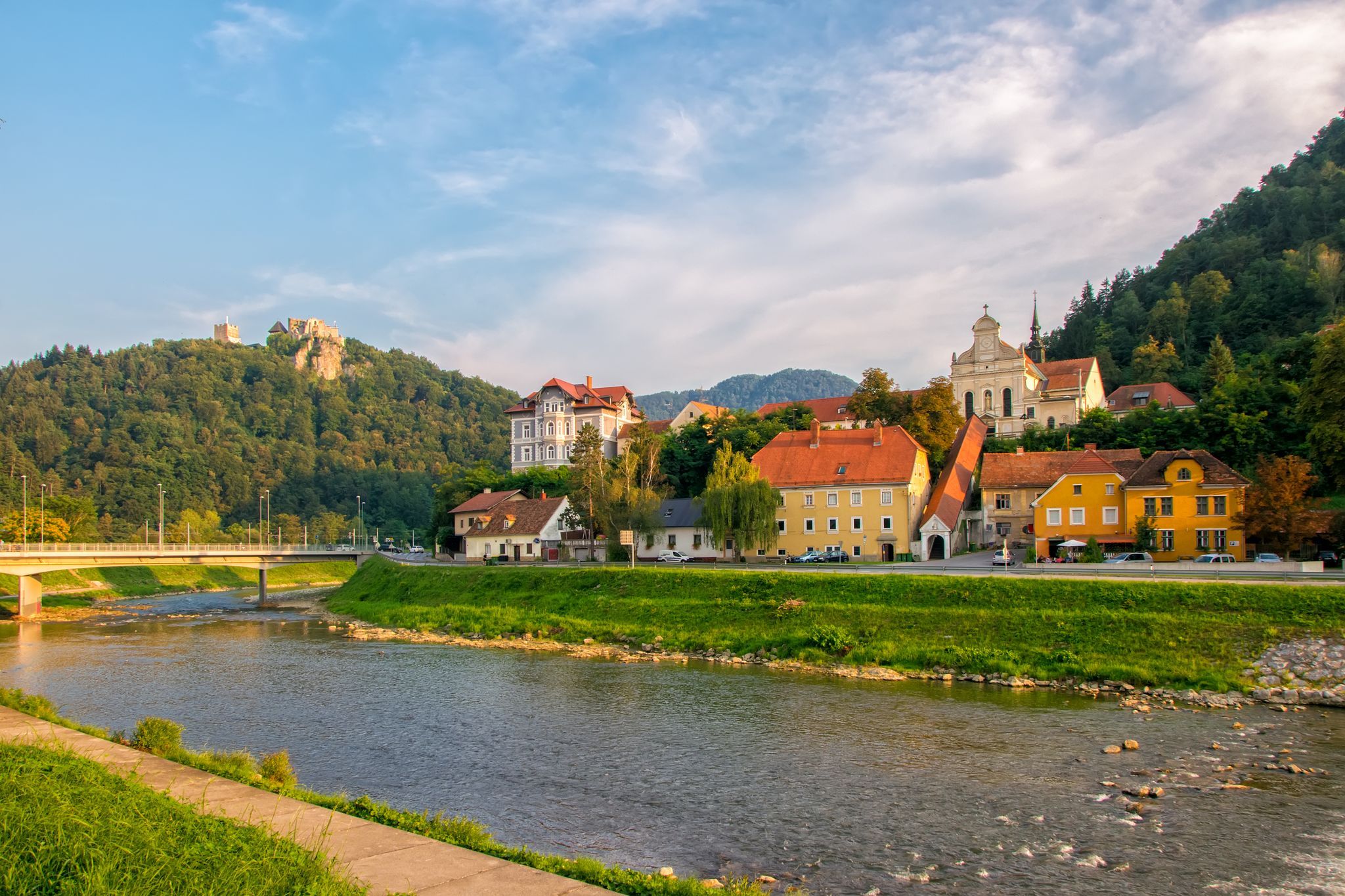 Scenic view on river Savinja, Capuchin monastery, houses in Breg and castle hill in Celje, Slovenia at sunny summer evening