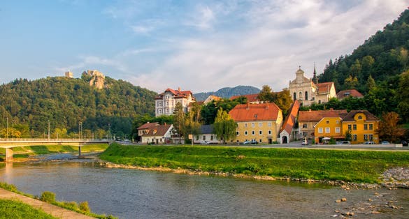 Scenic view on river Savinja, Capuchin monastery, houses in Breg and castle hill in Celje, Slovenia at sunny summer evening