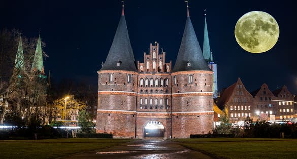 Holstentor in Luebeck with moon in the sky