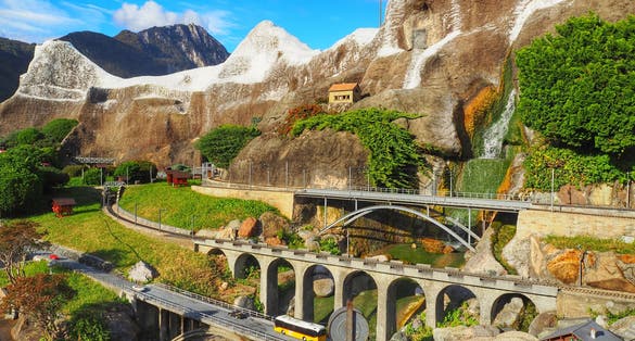 photo of Swissminiatur park in Melide, is an open-air museum with the most important Swiss buildings and means of transportation. Roads, bridges in Alps. Traffic and beautiful nature of Switzerland.