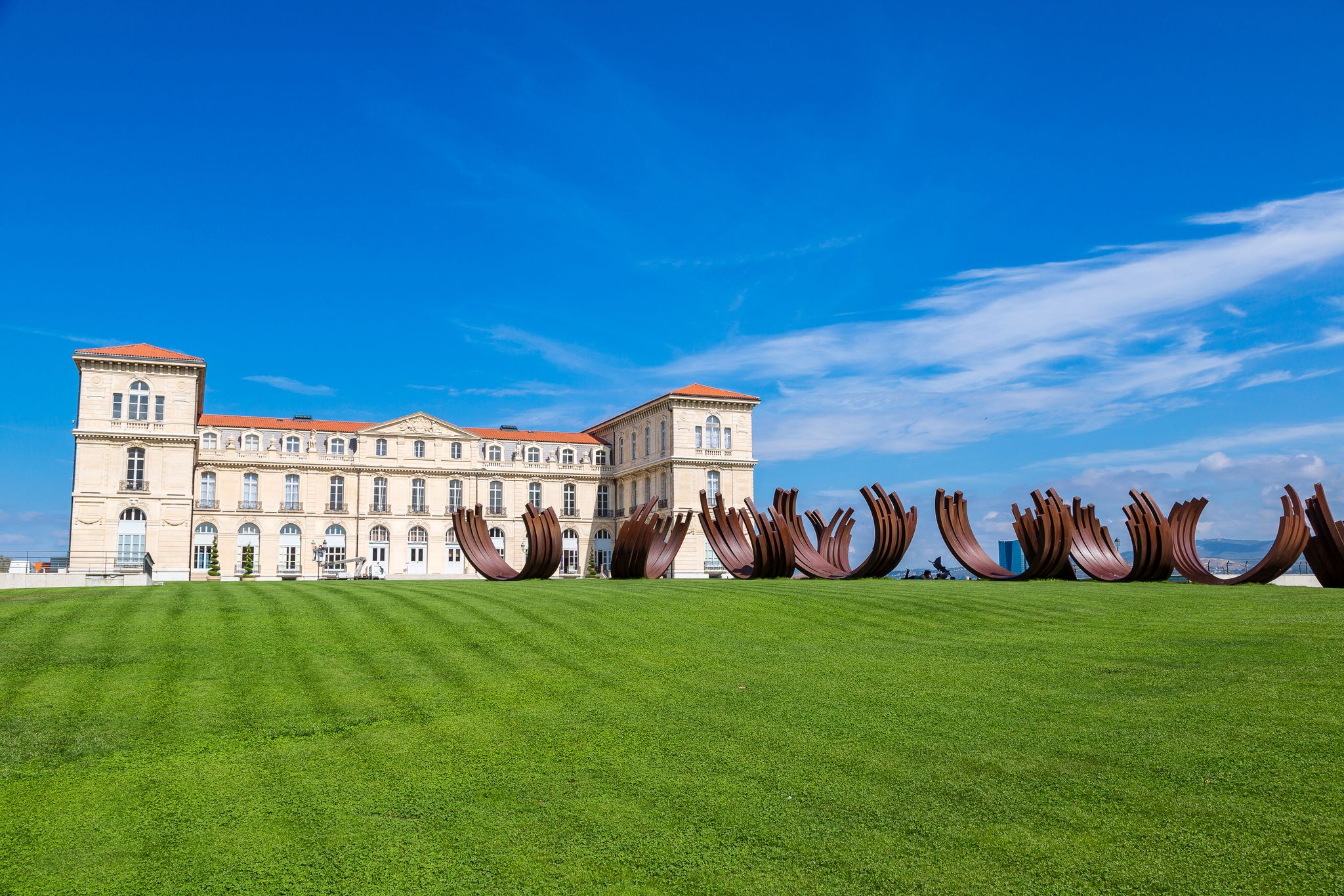 Palais du Pharo in Marseille, France, with contemporary metal sculptures displayed on the lawn under a clear blue sky..jpg