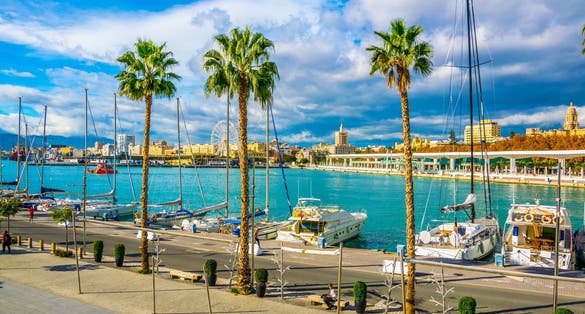 Photo of promenade surrounded by marina in the port of malaga in spain.