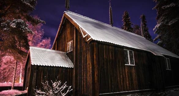 Photo of old wooden church of Sodankylä village at night in winter, Finland.
