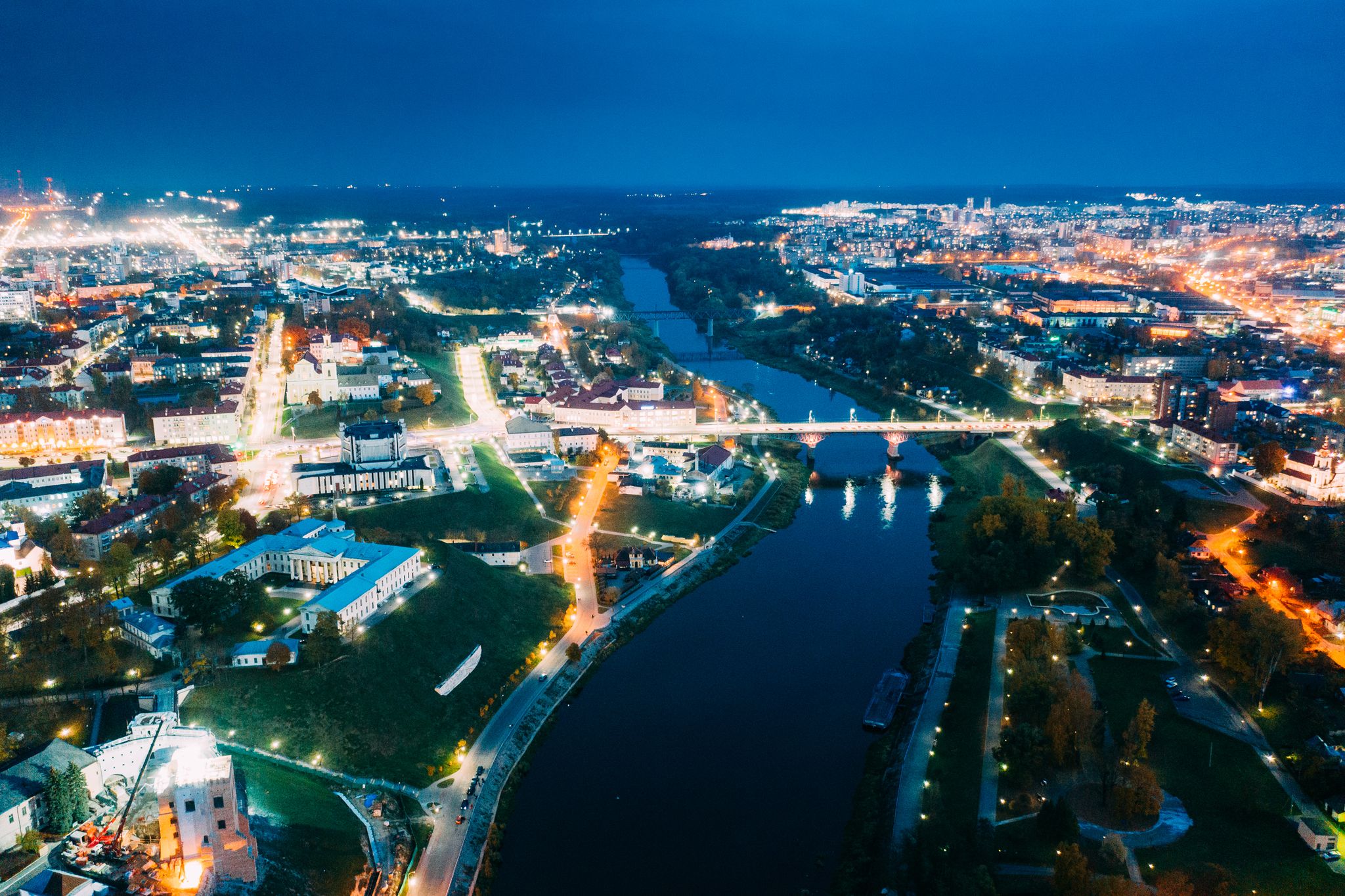 photo of view of Grodno, Belarus. Aerial Bird's-eye View Of Hrodna Cityscape Skyline. Famous Popular Historic Landmarks In Night Lightning. Theater, Catholic Church Of Discovery Of Holy Cross, Hrodna, Belarus.