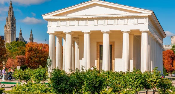 Photo of temple of Theseus in Volksgarten park with City Hall at background, Vienna, Austria.