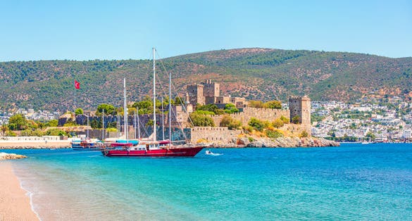 photo of panoramic view of Saint Peter Castle (Bodrum castle) and marina view of Bodrum beach in the foreground in Bodrum, Turkey.