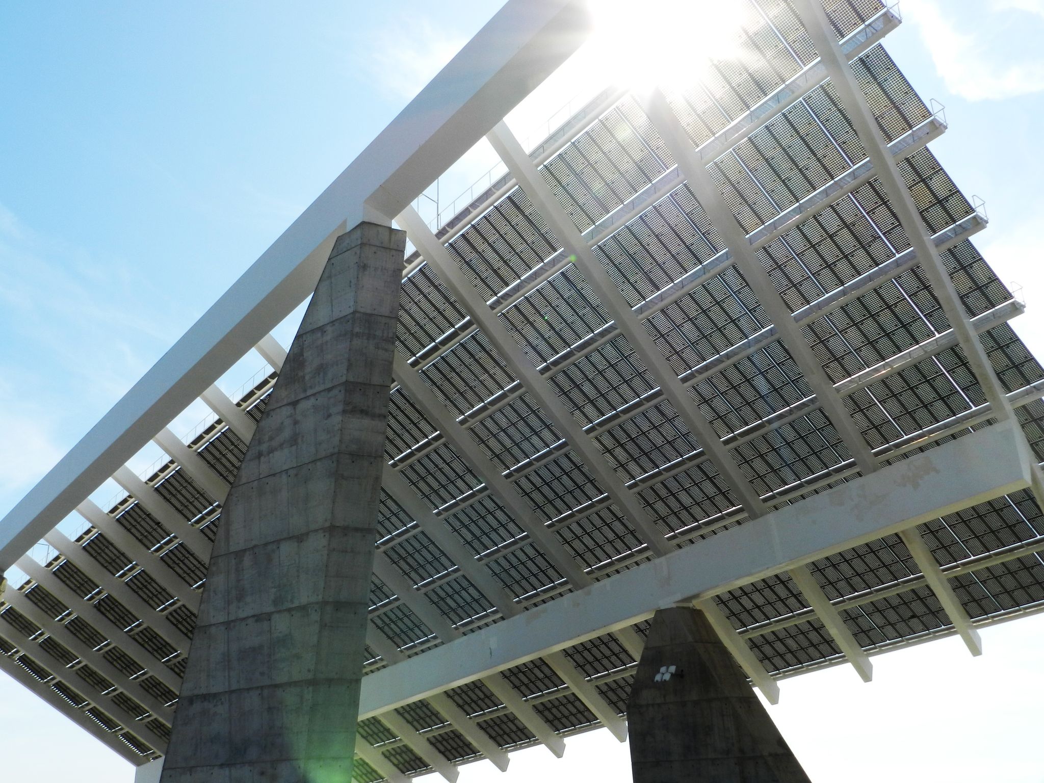 Photo of View of a giant solar panel in Parc del Forum, Barcelona, Catalonia/Spain. Sun behind the solar panel with sunbeams.