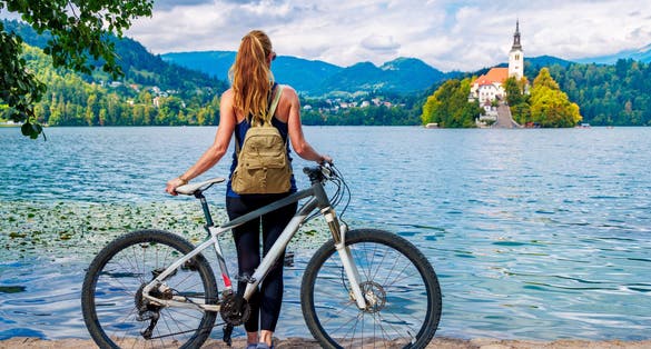 Woman tourist with mountain bike enjoying famous Bled lake- Travel, tour tourism, sport in Slovenia- Europe