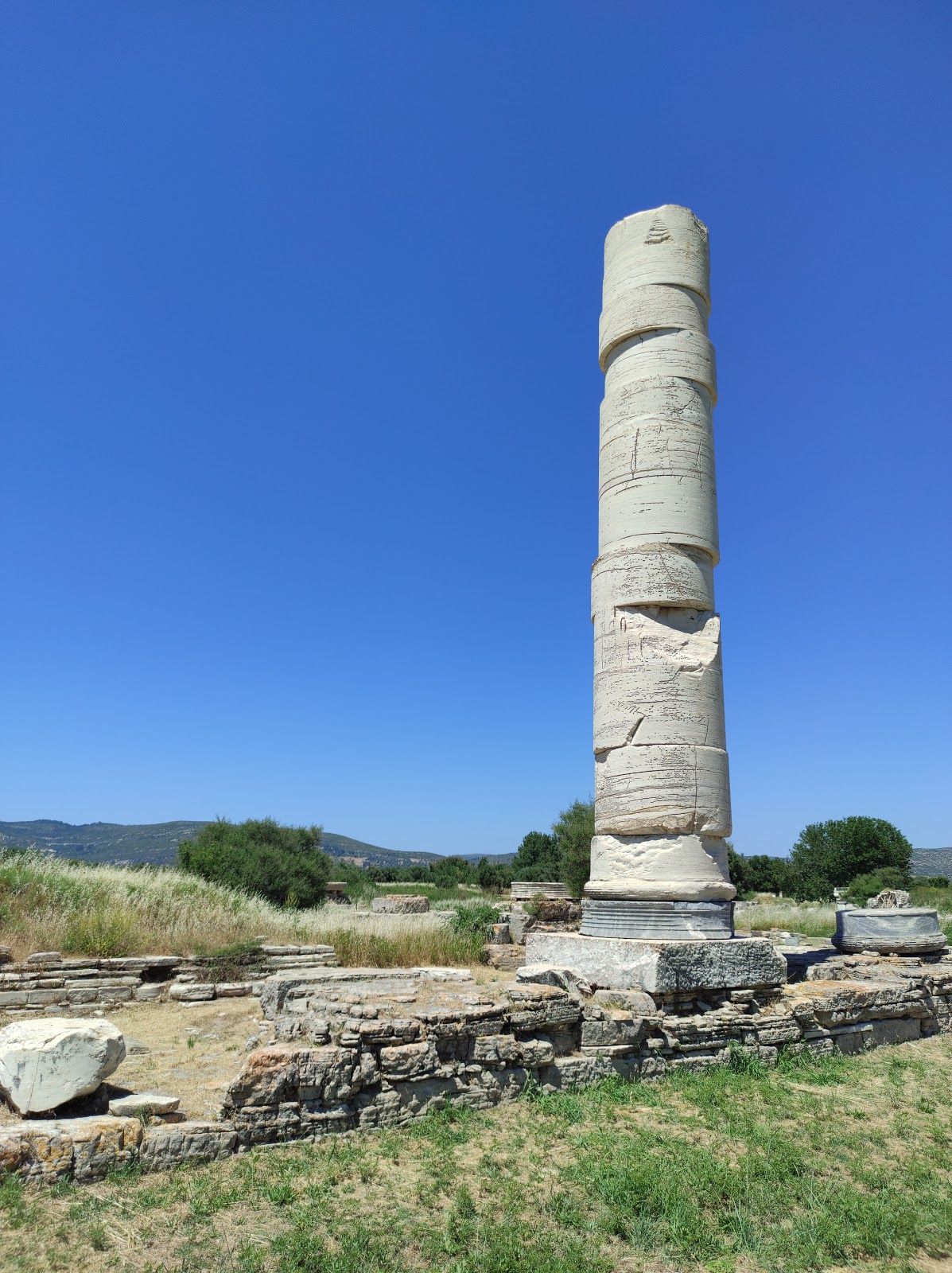 Photo of aerial view of Pythagorio port with colourful houses and blue sea, Samos island, Greece.
