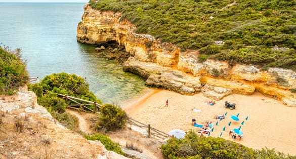 Photo of beautiful sandy beach surrounded with cliffs called Barranco, Porches, Algarve, Portugal.