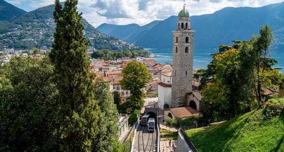 Photo of Lugano City - Ticino - during late Summer with the funicular and the San Lorenzo Church and the Lago di Lugano in the background, Switzerland.
