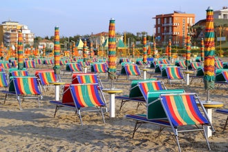 Photo of empty beach with a lot of sunbeds and umbrellas in Viserba, Rimini, Italy.