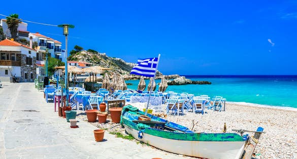 Photo of Samos island, Greece. Beautiful beach and tavern in scenic Kokkari village.