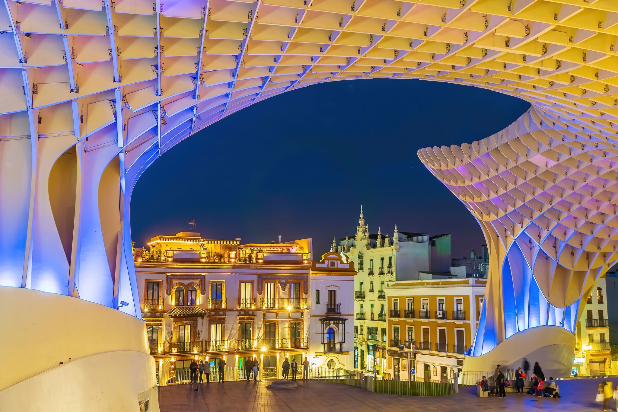 Photo of Metropol Parasol wooden structure with Seville city skyline in the old quarter of Seville in Spain at night.