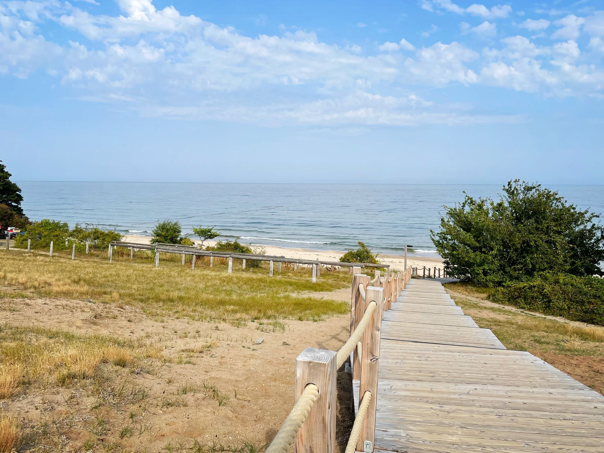 photo of empty footpath to the beautiful beach on a summer day. Scenic coastal landscape with the ocean in the background. Photo taken at Stenshuvud national park in Sweden.