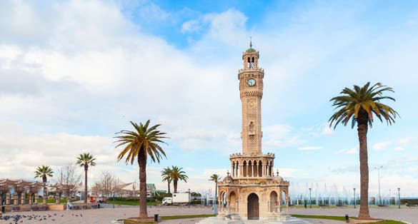 photo of Konak Square view with palm trees and old clock tower near Kemeraltı in Izmir City, Turkey.