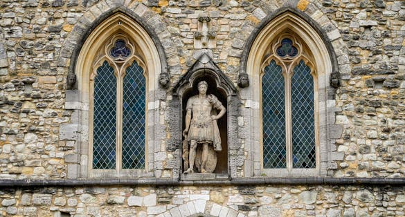 Photo of Statue of King Edward III between two gothic windows of the Guildhall on the second floor of the Bargate, a medieval gatehouse in the city of Southampton in the south of England.
