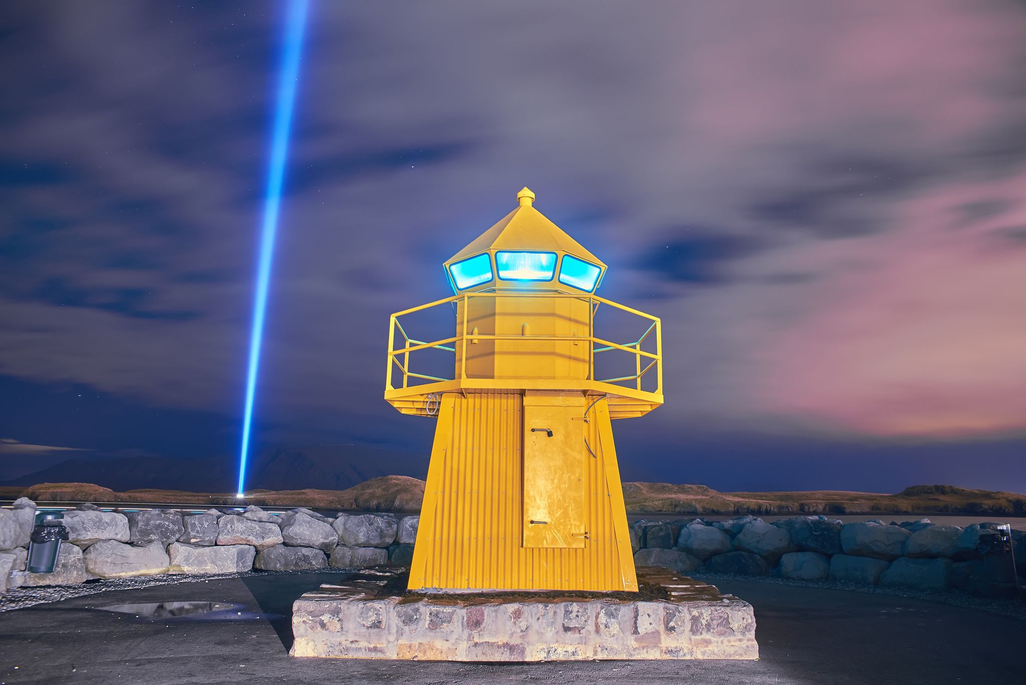 photo of view of Lighthouse and Imagine Peace Tower on Videy island in Reykjavik at night, Reykjavík, Iceland.