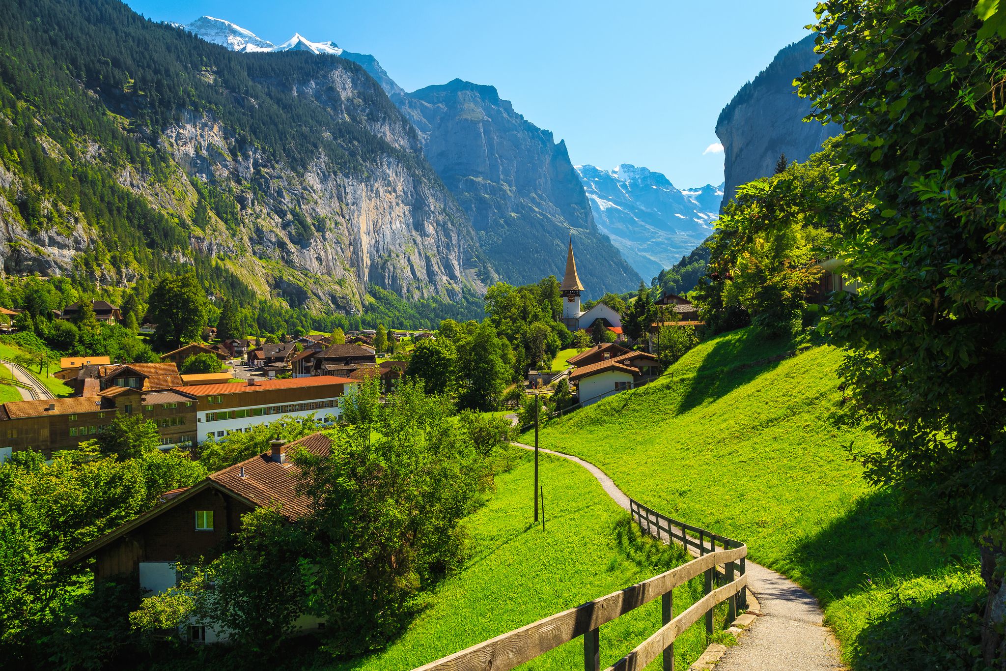 Photo of Beautiful tourist alpine village in the spectacular deep valley. Fantastic travel and touristic destination, Lauterbrunnen village with glaciers in background, Bernese Oberland, Switzerland, Europe .