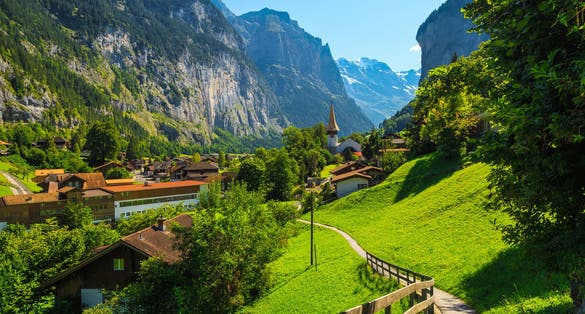Photo of Beautiful tourist alpine village in the spectacular deep valley. Fantastic travel and touristic destination, Lauterbrunnen village with glaciers in background, Bernese Oberland, Switzerland, Europe .