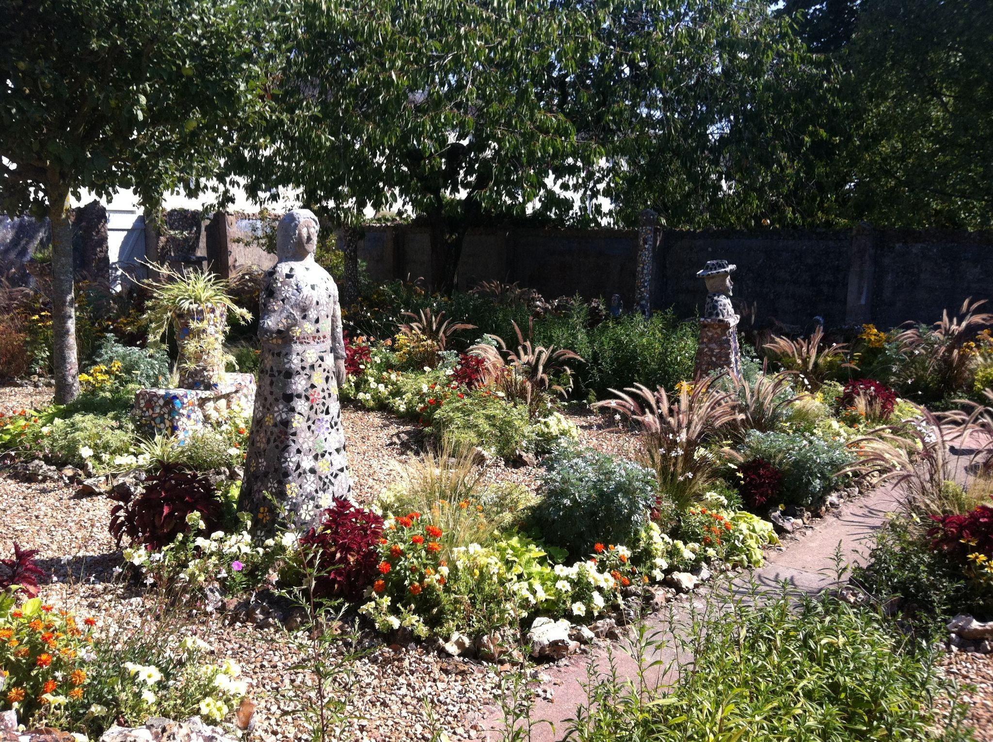 photo of flowers garden and mosaic statues at Maison Picassiette in Chartres, France.