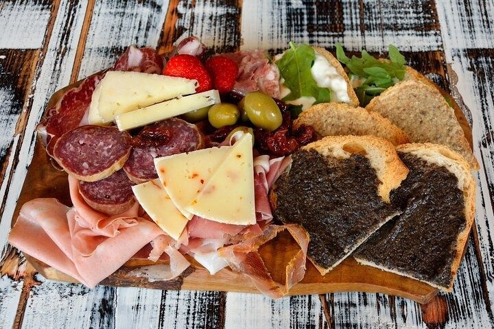 Italian charcuterie board with cured meats, cheeses, olives, and truffle toast on rustic wood..jpg