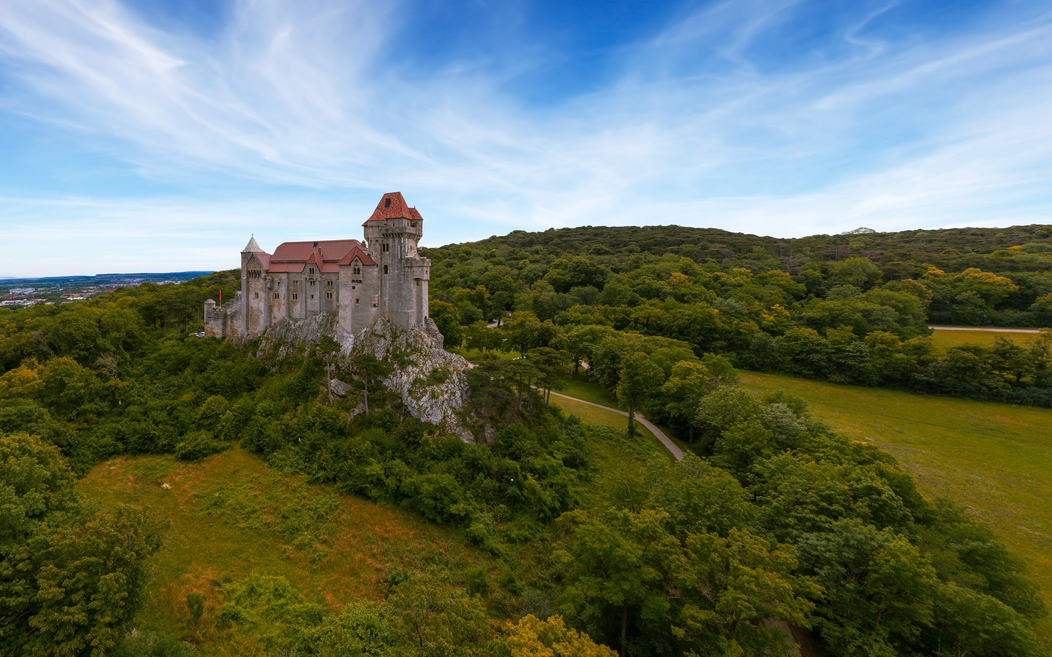 Photo of Liechtenstein Castle from the sky during sunset. The Liechtenstein Castle, situated on the southern edge of the Vienna Woods, Austria. Breathaking view about a medieval castle.
