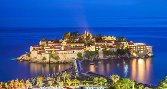 Photo of Night Sveti Stefan view with lights in windows, small islet and hotel resort in Montenegro.