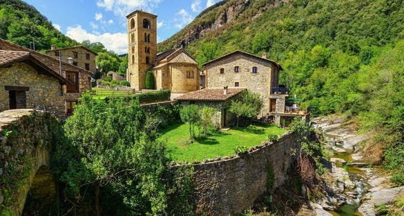 Photo of spectacular mountain village with old houses made of stone and Romanesque church with bell tower, Beget, Girona, Catalonia.