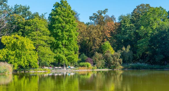 Photo of Karlsruhe palace during a sunny day viewed from Schlossgarten park in Germany.