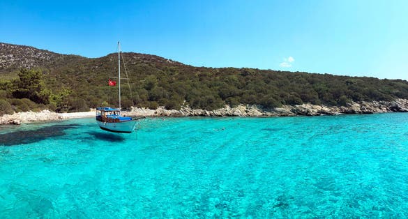 Photo of Aquarium bay Bodrum Mugla Turkey with a boat on the sea.