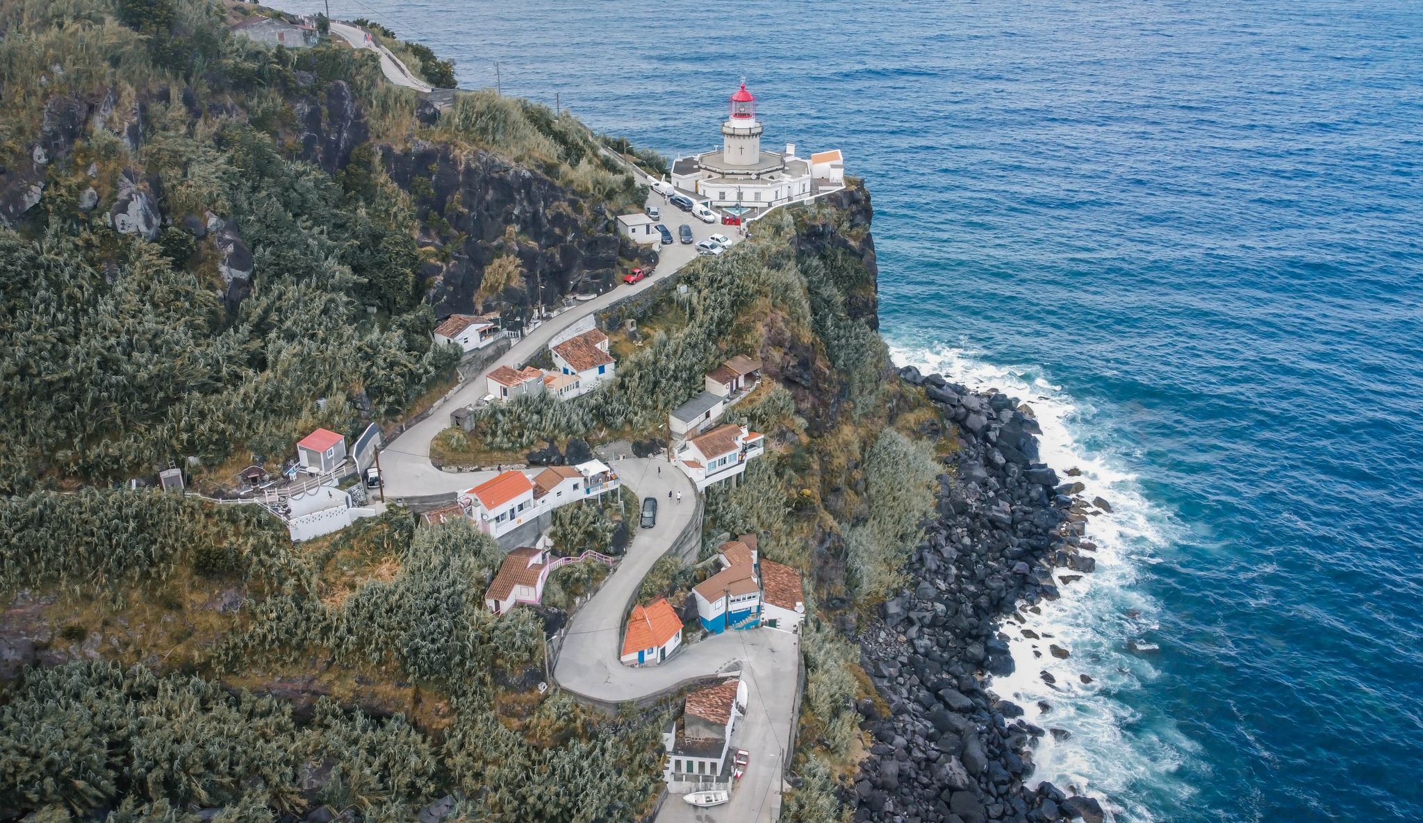 Photo of Aerial view of a curvy road leading to a lighthouse in the Azores Islands (Farol da Ponta do Arnel ).