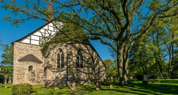 Photo of 1000 year old Stiepeler village church in the city of Bochum. Surrounded by a historic cemetery.