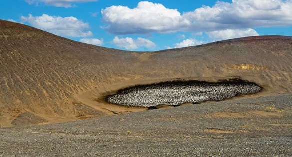photo of Barren dry volcanic hill with stain dirty ice rest - Grábrók Area, Iceland Highlands .