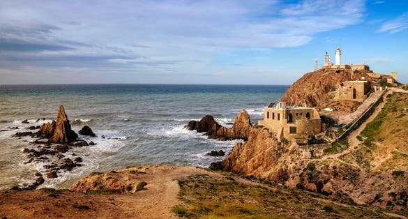 photo of Cape Gata lighthouse panoramic view on the coastline of Cabo de Gata-Nijar Natural Park, Almería, Andalusia, Spain.