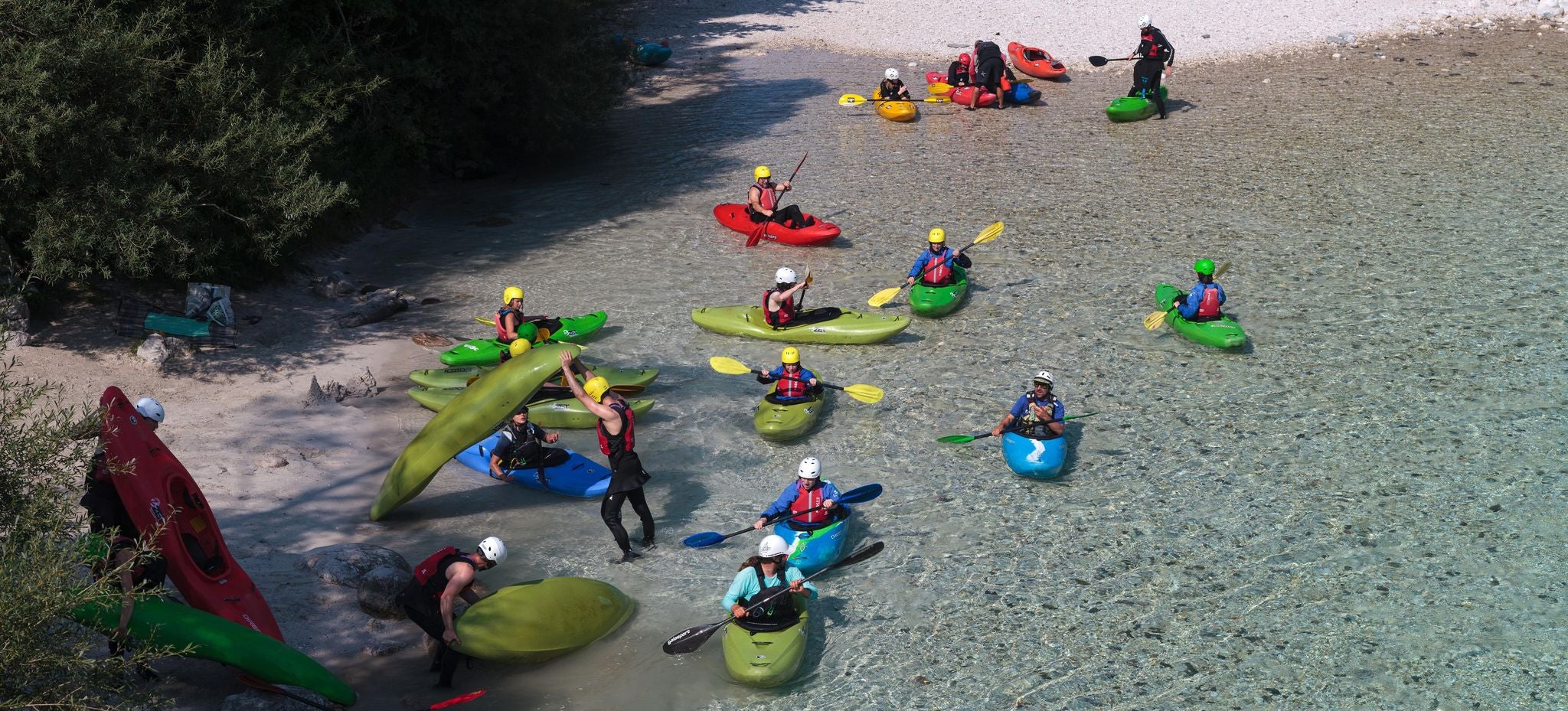Group of kayakers preparing to paddle in the clear turquoise waters of the Soca River in Slovenia..jpg