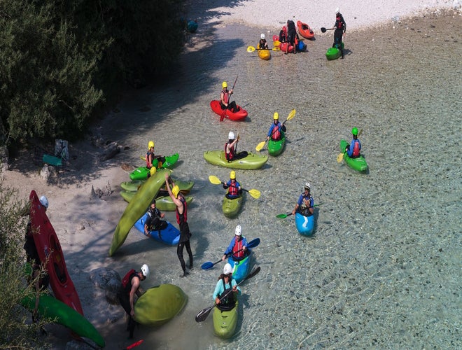 Group of kayakers preparing to paddle in the clear turquoise waters of the Soca River in Slovenia..jpg