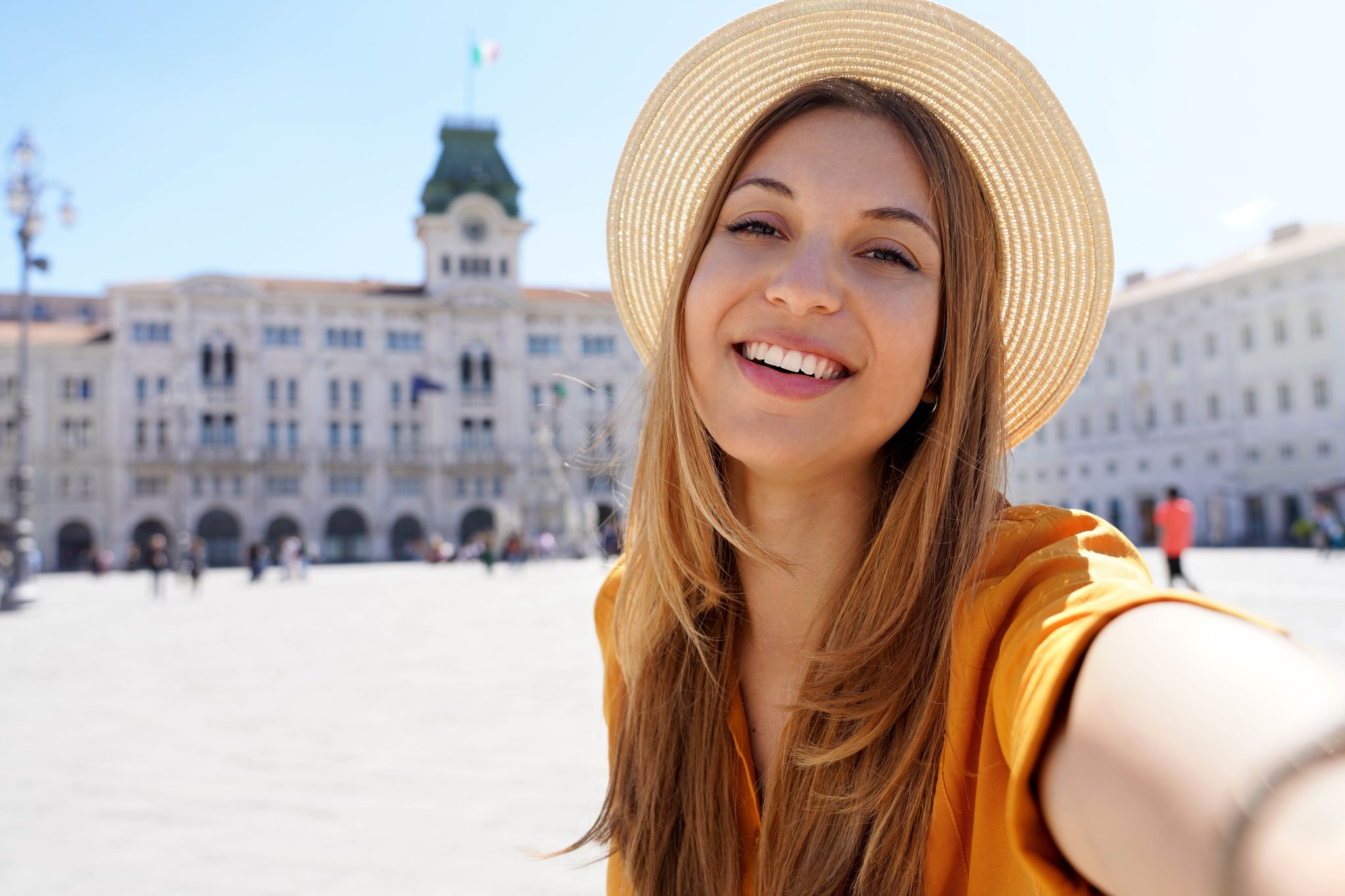 photo of cultural tourism in Italy. Self portrait of smiling traveler girl visiting piazza unità d'Italia Trieste, Italy.