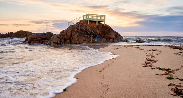 View point or gazebo over the rocks on a beach in Vila do Conde, Portugal, at sunset.