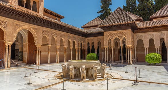 Photo of Patio de los Leones inside of the Nasrid palace of Alhambra fortress in Granada, Spain.