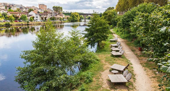 Photo of chaise lounges on a pathway along the Vienne River in Limoges.