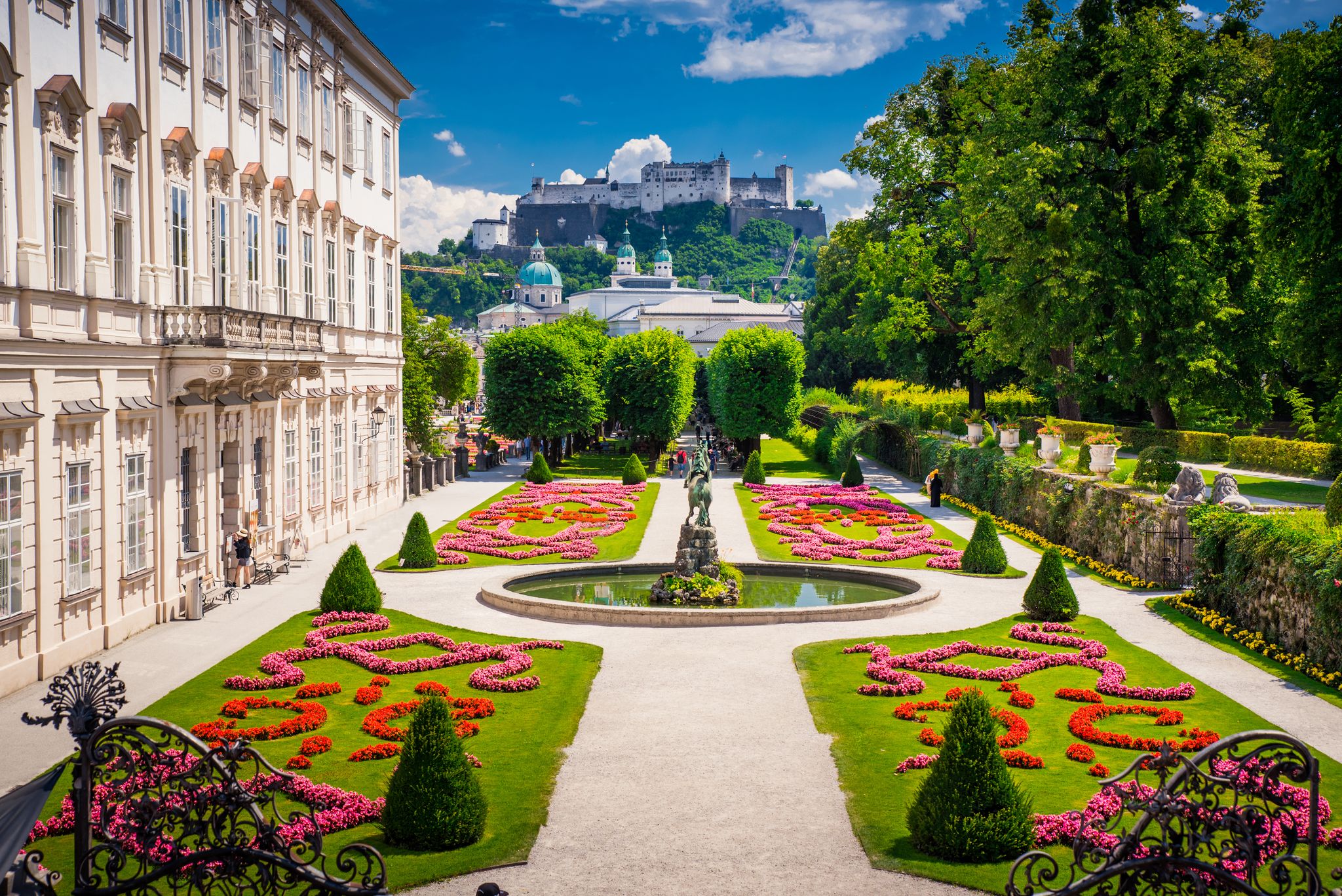 Photo of Mirabell Palace and Gardens in Summer, Salzburg castle in background.