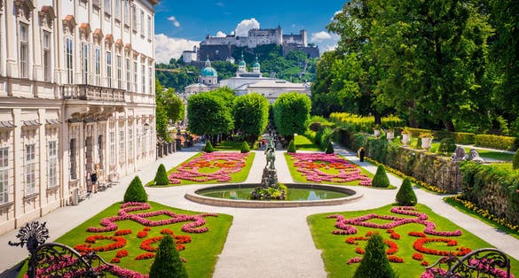 Photo of Mirabell Palace and Gardens in Summer, Salzburg castle in background.