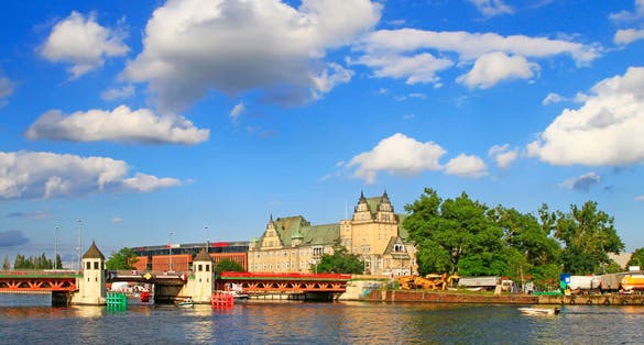 Photo of landscape of Szczecin with the red metallic bridge with towers across the Oder river, Poland.