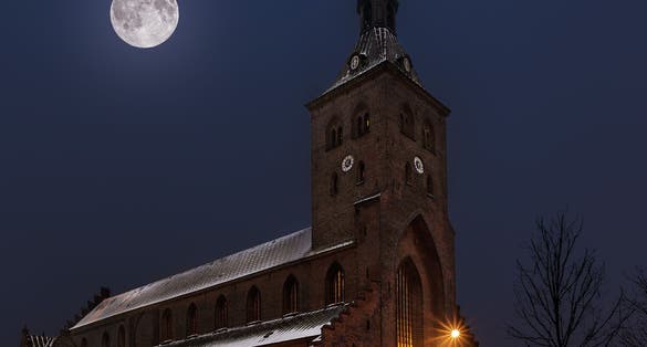 Photo of St. Canute's Cathedral at night in the center of Odense, Denmark.