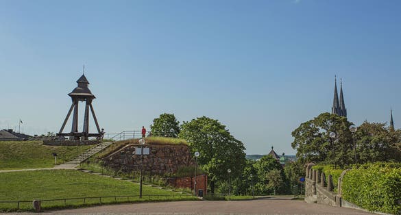 photo of Gunillaklockan in beautiful park near the Uppsala Castle with Green trees on blue sky background in Uppsala, Sweden.