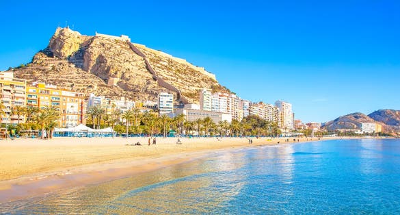 Photo of postiguet beach and coastline in Alicante resort town, Spain.